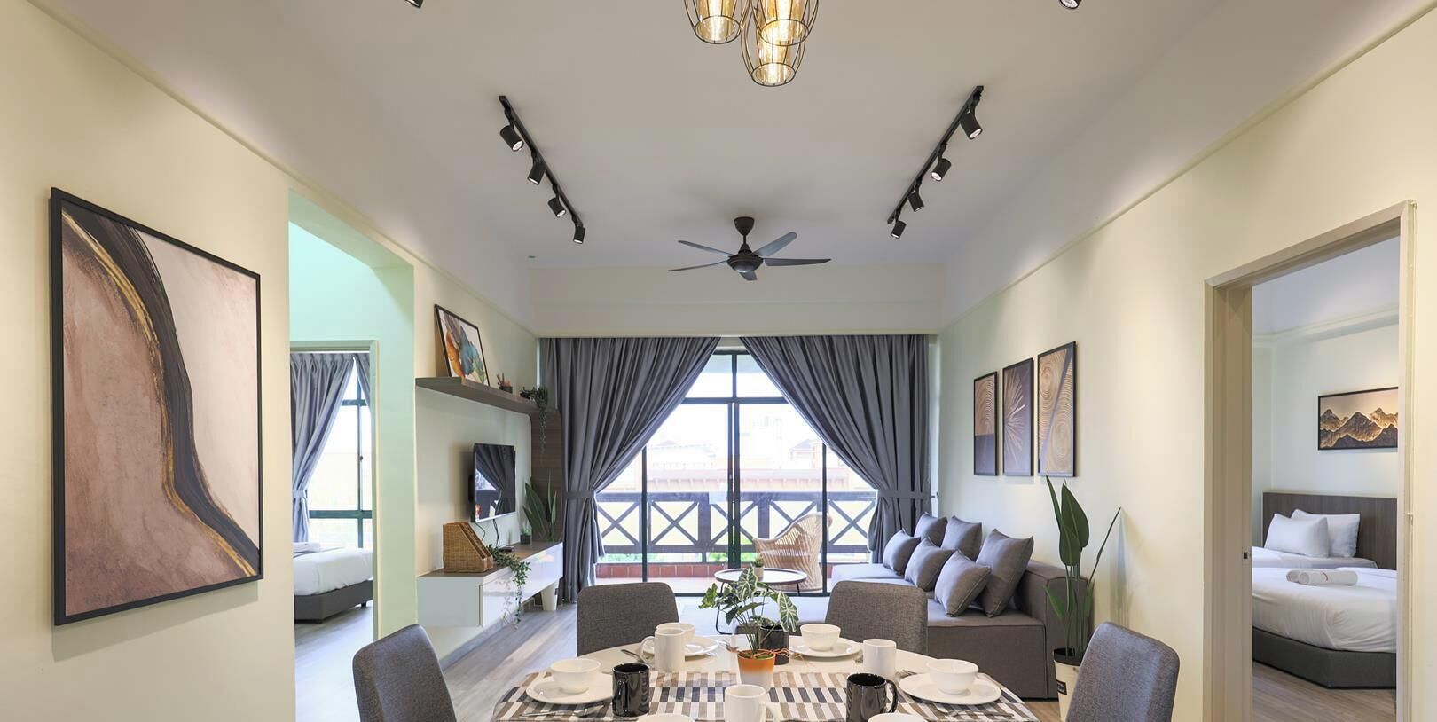 A hotel room with a dining area, a bed, and a balcony with a view.