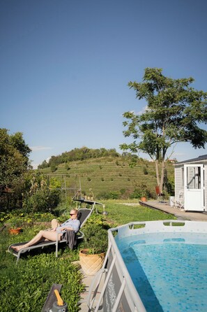 A person relaxing by a pool with a view of a hillside.