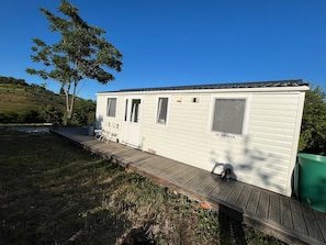 Una casa móvil con terraza, ventana y puerta.