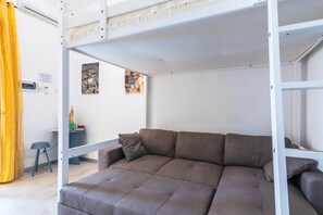 A bunk bed with a brown mattress, a small table with a lamp, and a yellow curtain. - Apartment "Sicania" with Balcony, A/C & Wi-Fi (Noto)