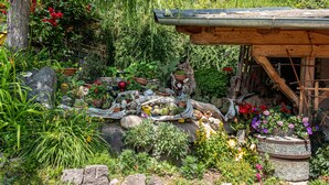 A garden with various plants and a rustic wooden structure. - Apartment 'Gamperhof Latemar' with Mountain View, Shared Terrace and Whirlpool (Karneid/Gummer)