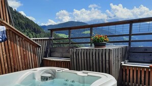 A hot tub with a wooden deck and a view of mountains. - Apartment 'Gamperhof Latemar' with Mountain View, Shared Terrace and Whirlpool (Karneid/Gummer)