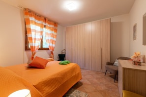 Ein Schlafzimmer mit einem Bett, einem Schreibtisch, einem Stuhl und einem Kleiderschrank.