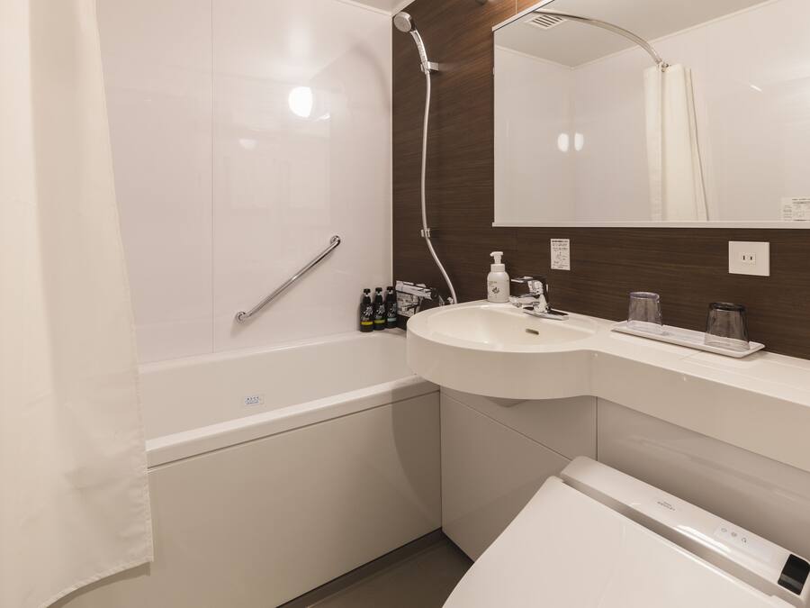 Un baño moderno con bañera, lavamanos y espejo.