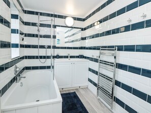 Une salle de bain moderne avec une baignoire blanche, une douche et un meuble-lavabo avec un miroir.