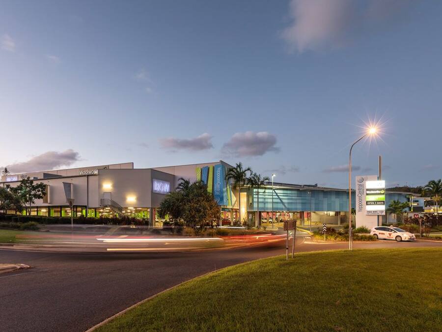A modern building with a glass facade, a McDonald's sign, and a sign for a dental clinic.