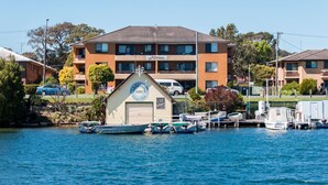 Une propriété située au bord de l’eau, dotée d’une marina, d’un bâtiment sur lequel on peut lire l’inscription « Akuna », et de plusieurs bateaux amarrés.