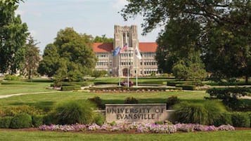 The University of Evansville campus with a central building, flag, and well-maintained lawn.