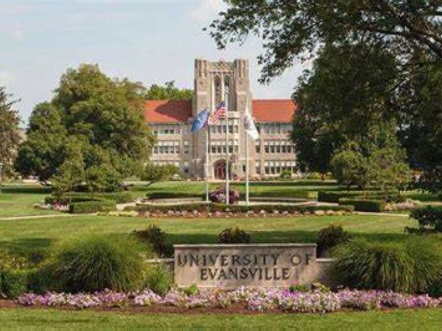 The University of Evansville campus with a central building, flag, and well-maintained lawn.