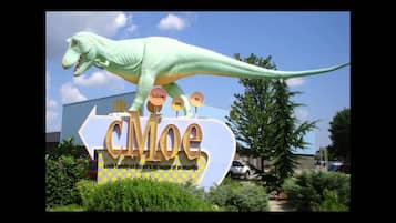A dinosaur statue on a sign for the Koch Family Children's Museum of Evansville.