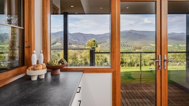 A modern kitchen with a large window overlooking a scenic landscape. - The Grove Estate - The pièce de resistance of this property is the view, be it the 360-degree views of the surrounding bush side, valley and the Region’s famous Mt Buffalo or perhaps the view of the spectacular and famous artwork showcased through th (Porepunkah)