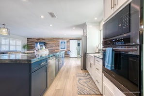 Enjoy cooking in this well-lit kitchen with a large island, sleek cabinetry, and stainless steel appliances.