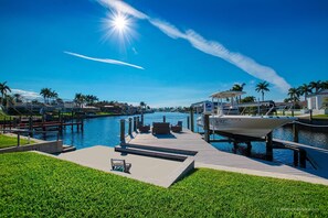 Enjoy waterfront views from the marina, where a boat is docked and houses are visible in the distance.