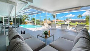 Ein großzügiger Außenbereich mit Pool, bequemen Sitzgelegenheiten und Blick auf die umliegende Gegend.