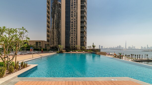 En swimmingpool med utsikt över en hög byggnad och en stadsbild i bakgrunden.