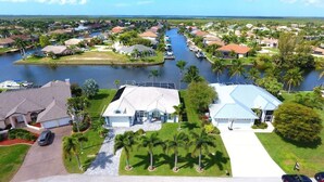 A residential area with houses, a canal, and a boat dock. - VRCC Villa Sansibar (Cape Coral)