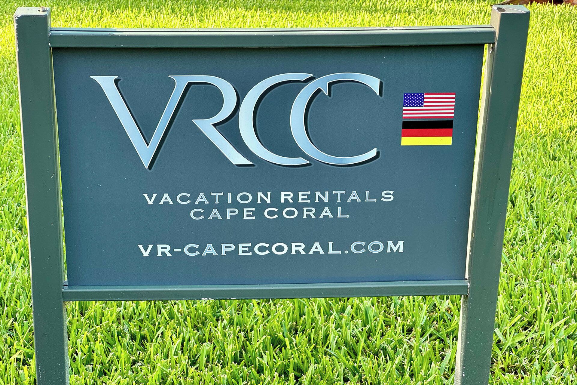 A signboard with the text 'VACATION RENTALS CAPE CORAL' and a website address 'VR-CAPECORAL.COM'.