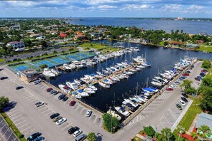Marina com barcos atracados, estacionamento e áreas residenciais ao redor.