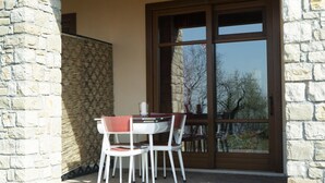 A stone wall, a glass door with a view, and a table with chairs.
