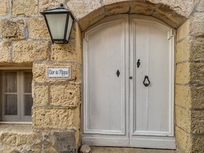A stone building with a white double door and a sign reading "Dar ta Pippa".