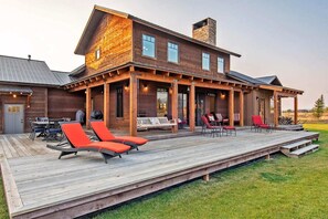 Une maison en bois dotée d’une terrasse, d’un espace salon extérieur et d’un patio couvert.