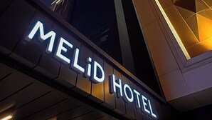The exterior of the Melid Hotel with a prominent illuminated sign. - Melid Hotel (Malatya)