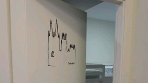A door with a hand-drawn graph and the word "Catholic" on the wall. - Hostel Trovadores (Burgos)