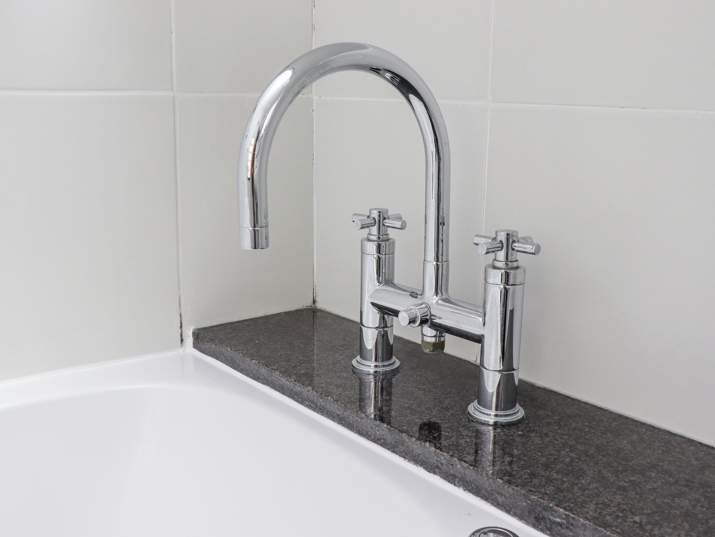 Une salle de bain avec un robinet chromé, un lavabo et un comptoir en marbre.