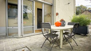 A patio with a round table, four chairs, a potted plant, and a large orange pumpkin. - Vouvray - Beautiful castles (Vouvray)
