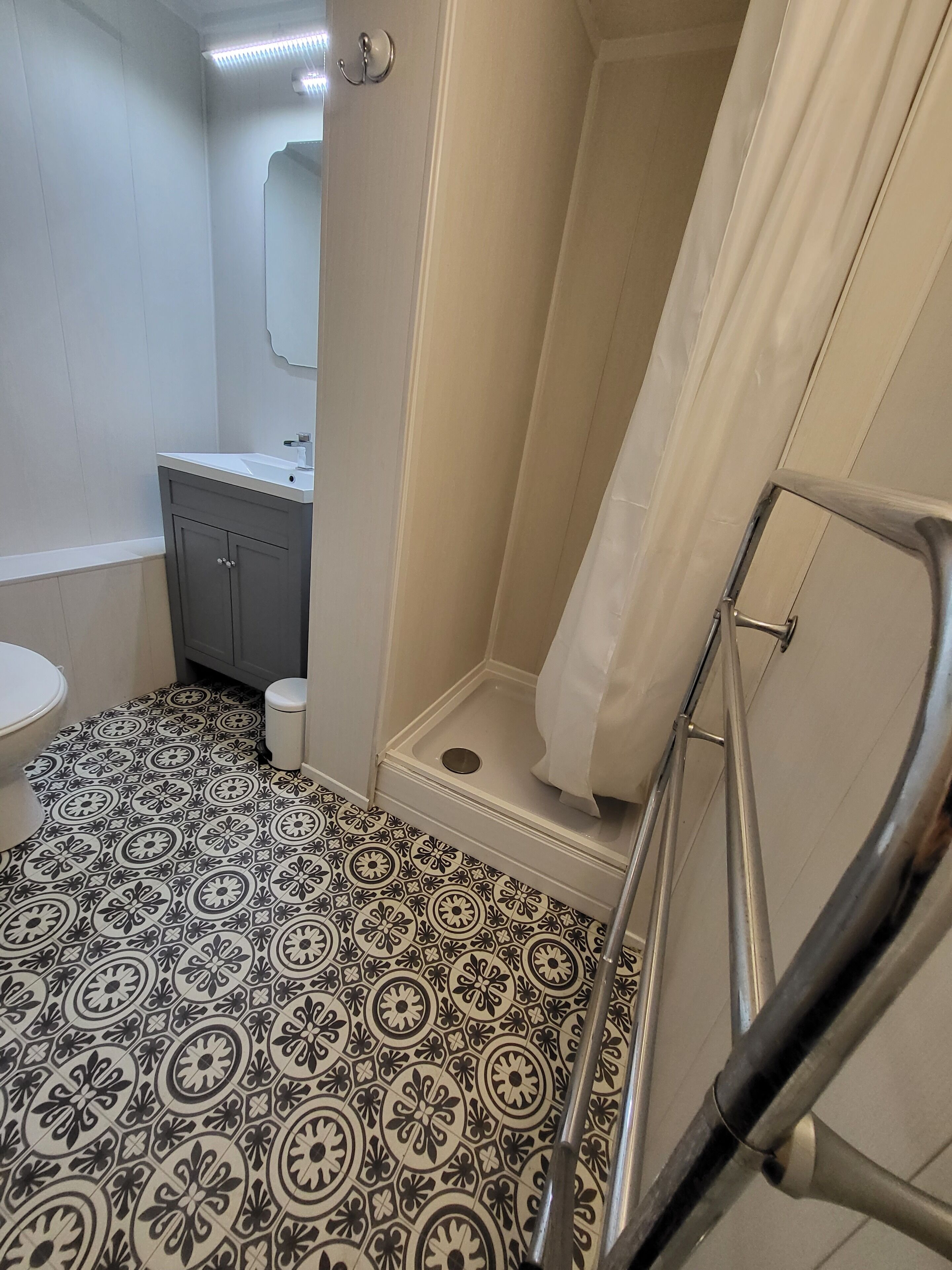 A bathroom with a shower, toilet, and sink.