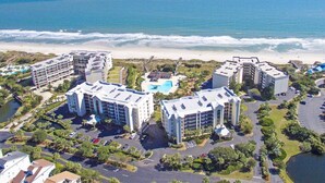 A coastal hotel complex with multiple buildings, a swimming pool, and a beach view. - Sandpiper CRD1C - Beautifully Decorated - Private Stairs to pool and beach (Pawleys Island)