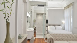 A modern hotel room with a bed, sofa, and a small desk with a chair. - 1900 Athenian House (Athens)