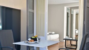A modern room with a dining area, a bed, and a bathroom visible through an open door. - 1900 Athenian House (Athens)