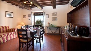 A cozy dining area with a wooden table, chairs, and a view of the outdoors. - Forte Sorgnano | Farmhouse with pool (Gualdo Cattaneo(PG))