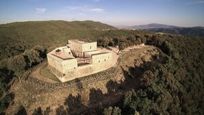 An ancient stone fortress with a circular wall, situated on a hill surrounded by dense forest. - Forte Sorgnano | Farmhouse with pool (Gualdo Cattaneo(PG))