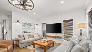 A modern living room with a sofa, coffee table, and TV. - 🏖Steps 2 Beach Access🏴‍☠️Pirate Themed🏝️Private Pool/Luxury/Location (Miramar Beach)