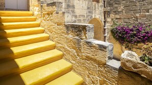 Ein Steingebäude mit einer Treppe, die zu einer weißen Tür führt.