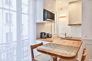 Une cuisine moderne équipée d’un four à micro-ondes, d’un grille-pain et d’une machine à café, le tout posé sur le plan de travail.