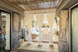 A room with a wooden floor, a woven canopy, and a stone sculpture. - Athens The L7 Str - Luxury Boutique Collection Hotel (Athens)
