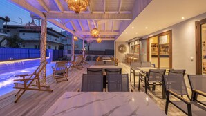 Un restaurant doté d’une terrasse, d’une piscine et offrant une vue sur les bâtiments environnants.