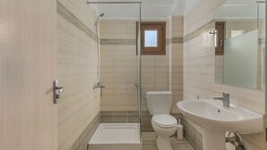 Une salle de bain moderne avec une douche à parois de verre, des toilettes et un lavabo.