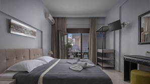 Une chambre d’hôtel moderne dotée d’un grand lit, d’un bureau, d’une télévision et d’un balcon avec vue.