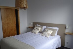 Cozy retreat with a single bed, two bedside tables, and a wooden door leading to the adjacent room.