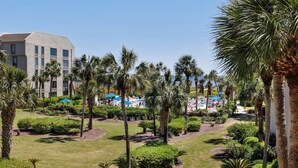 A resort with a pool area, palm trees, and a building with multiple windows. - 237 Shorewood Villas - Ocean Views - Exceptional Update - Discounted Rates! (Hilton Head Island)
