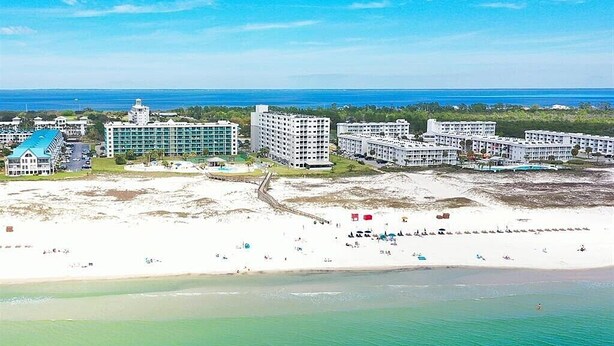A coastal resort with multiple hotel buildings, a sandy beach, and a clear view of the ocean. - Flip Flop O'Clock-Gulf Views • 6 Pools • Beachfront Resort Escape (Gulf Shores)