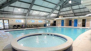 An indoor swimming pool with a hot tub, lounge chairs, and changing rooms. - Flip Flop O'Clock-Gulf Views • 6 Pools • Beachfront Resort Escape (Gulf Shores)