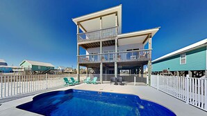 Ein zweistöckiges Gebäude mit Balkon und Schwimmbad.