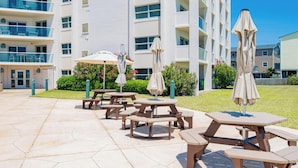 Un patio con mobiliario exterior y un edificio con varios balcones.