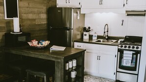 Una cocina con armarios de madera, un refrigerador, una estufa, un microondas y un ventilador de techo.