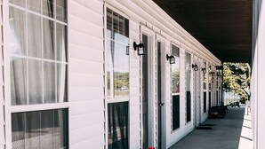 Una hilera de casas móviles blancas con ventanas grandes y un porche cubierto.
